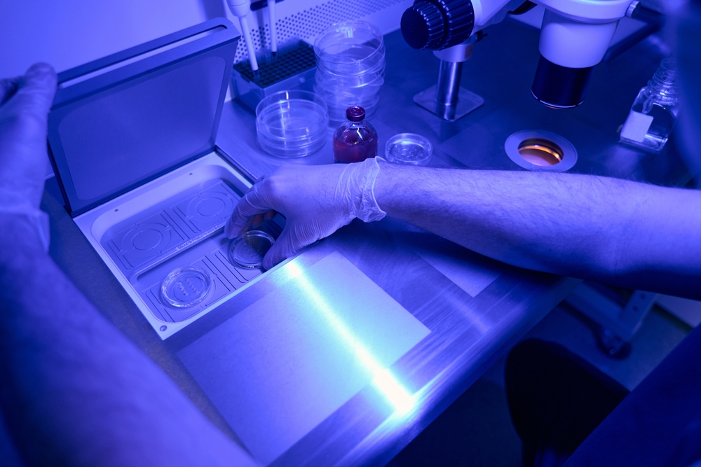 Genetic laboratory worker conducting research in uv light 