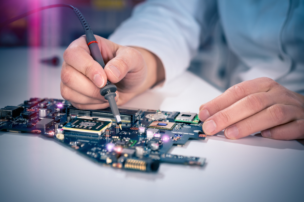 Tech fixes motherboard in Electronic lab