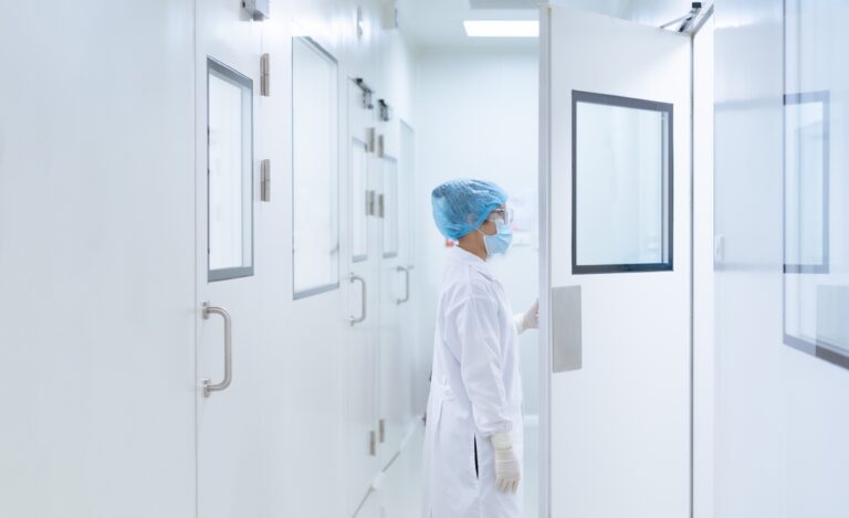 Microbiologist opening cleanroom lab door