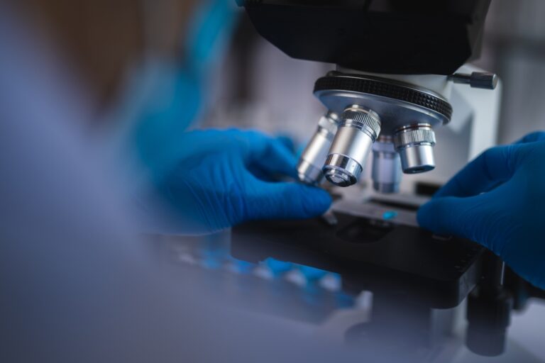 Scientist analyzing microscope slide at pathology lab