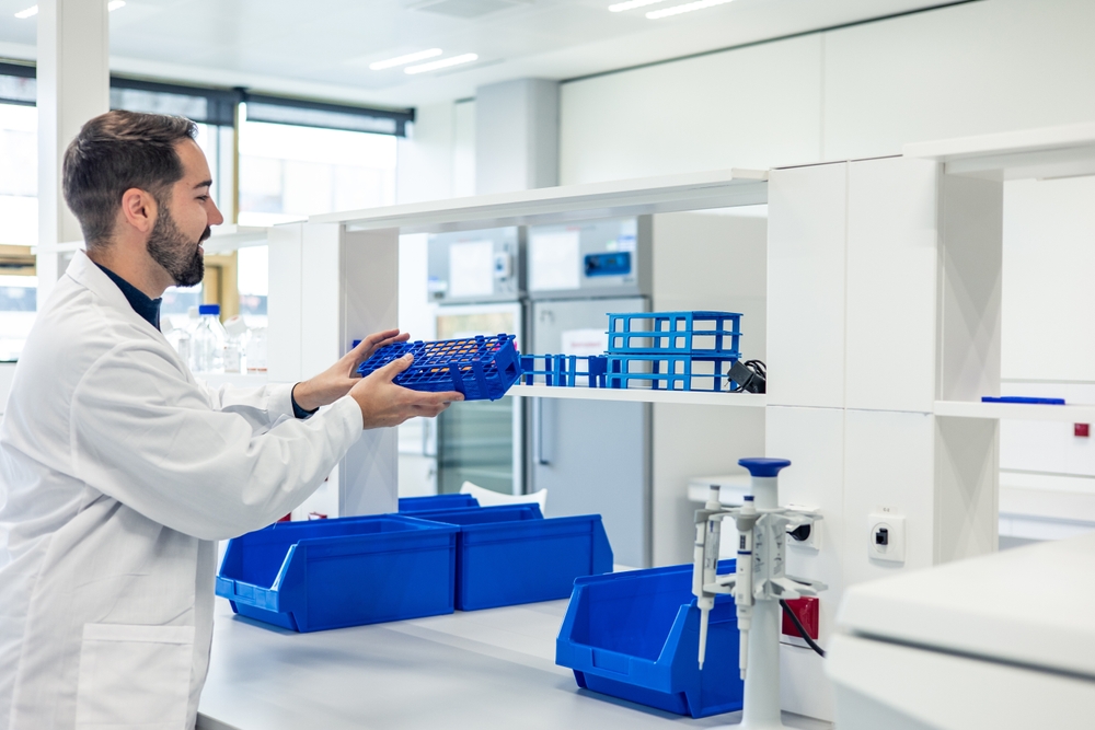 Scientist organizing laboratory materials on shelves in a modern lab 