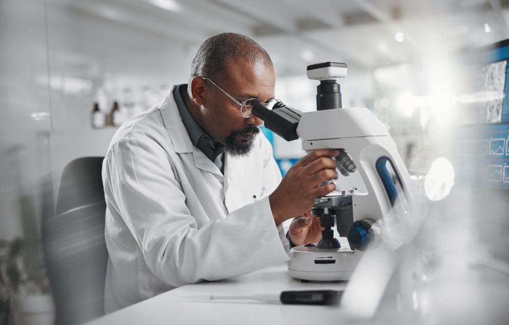 Scientist working with microscope in laboratory 